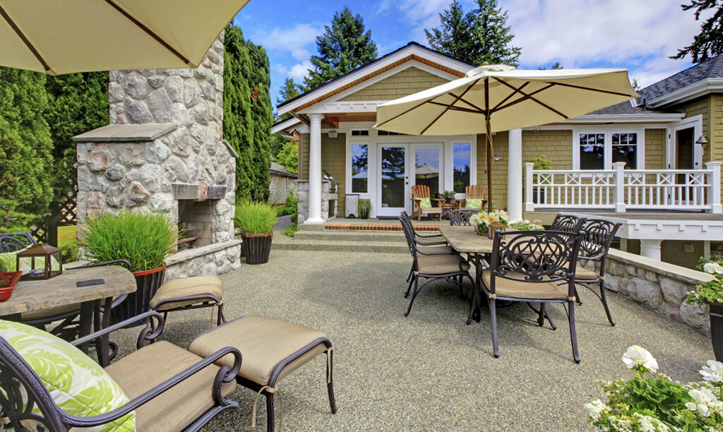 Patio area with stone fireplace and concrete floor.