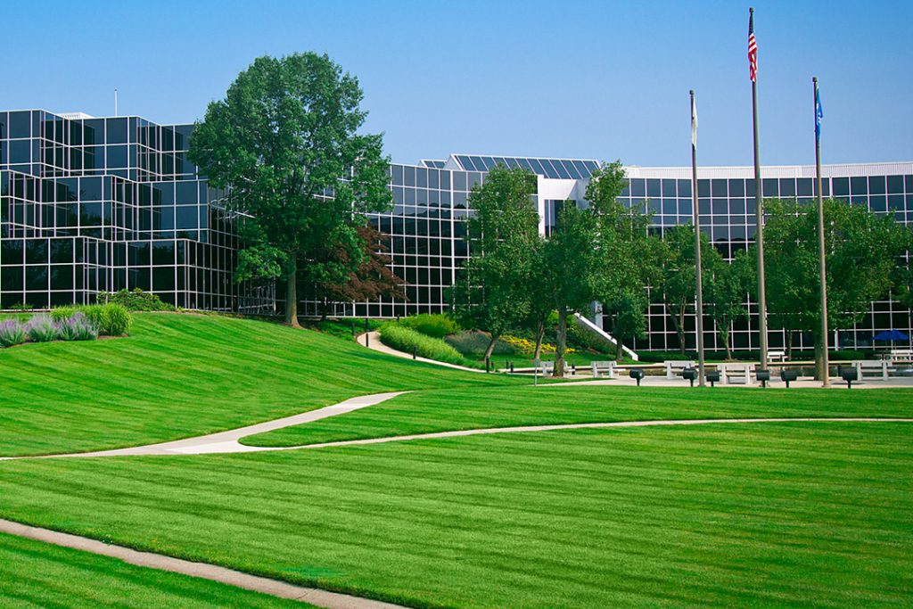 A large office building with grass in front of it.